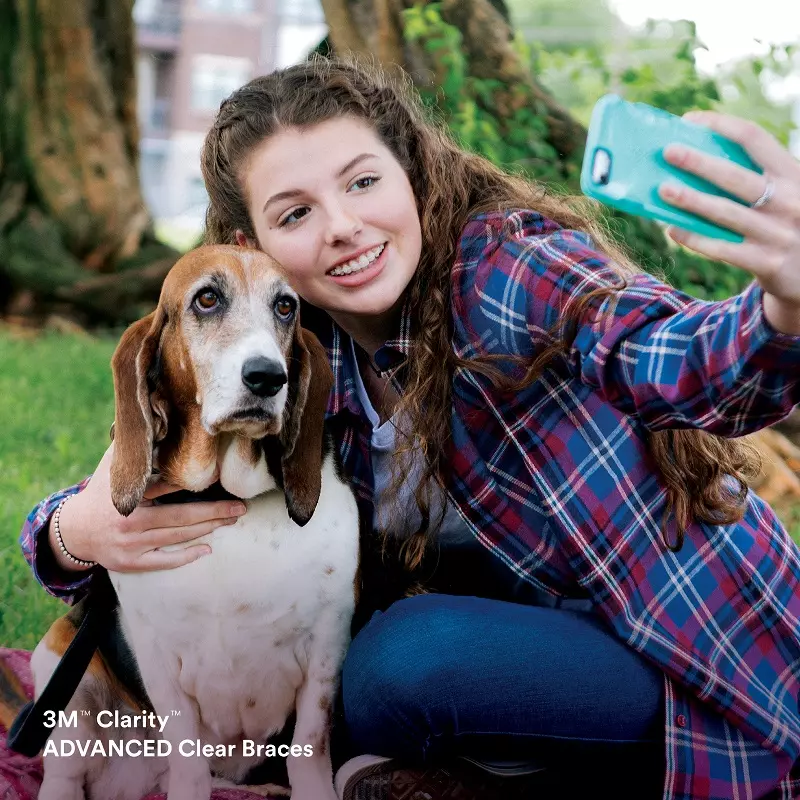 A woman taking a picture of herself and her dog.