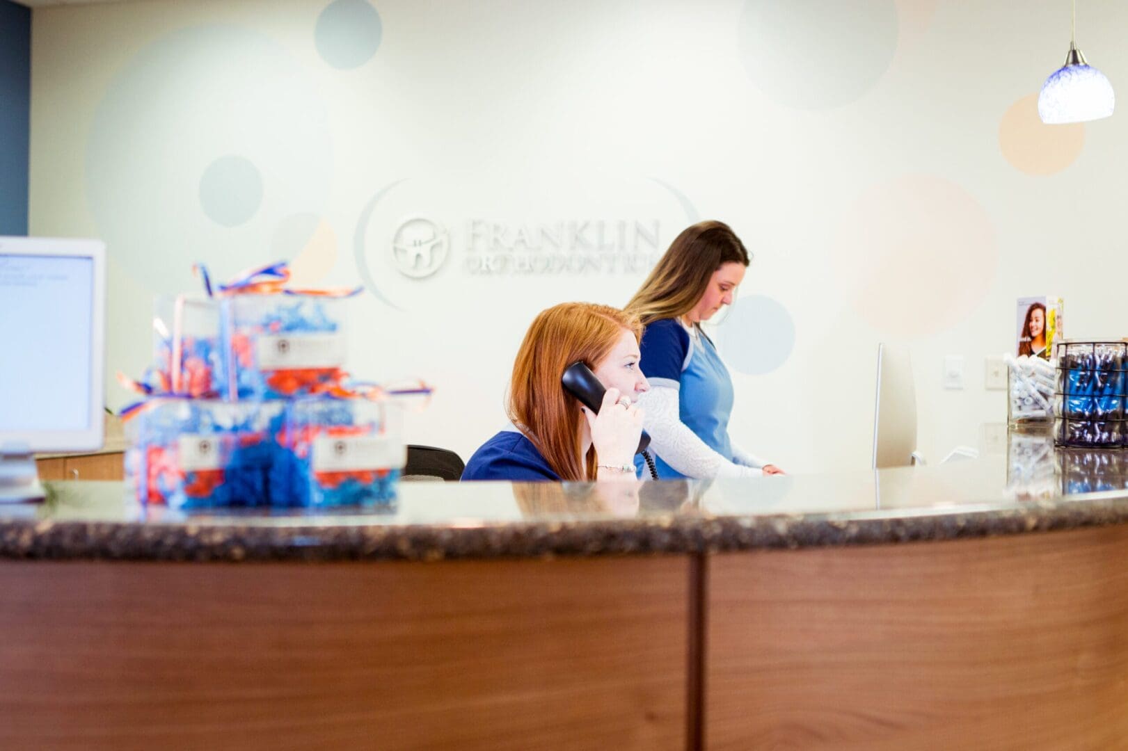 A woman is standing behind the counter of a hotel.